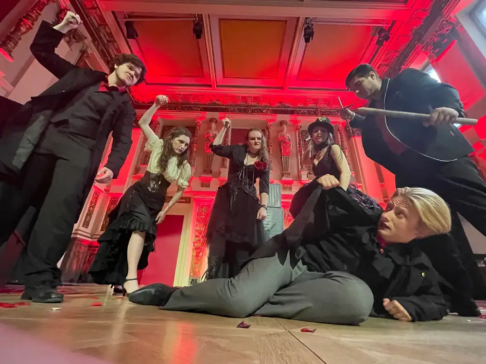 Opera Institute singers in a dramatic staged scene under red light